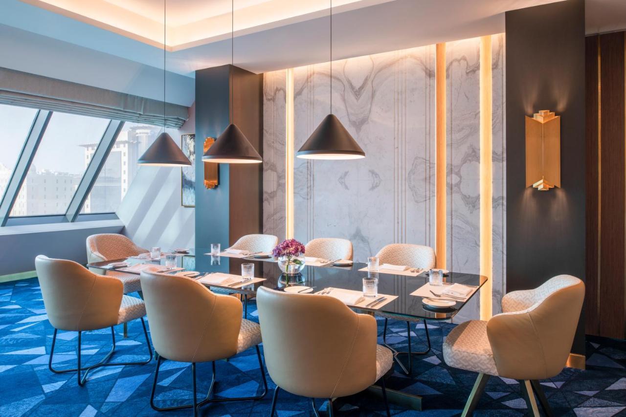 Steigenberger Hotel Doha Exterior foto The photo showcases a stylish meeting room. It features a modern, elegant design with a large rectangular table surrounded by plush chairs. The room has a contemporary color palette, primarily using soft beige and rich blue tones. Large windows allow
